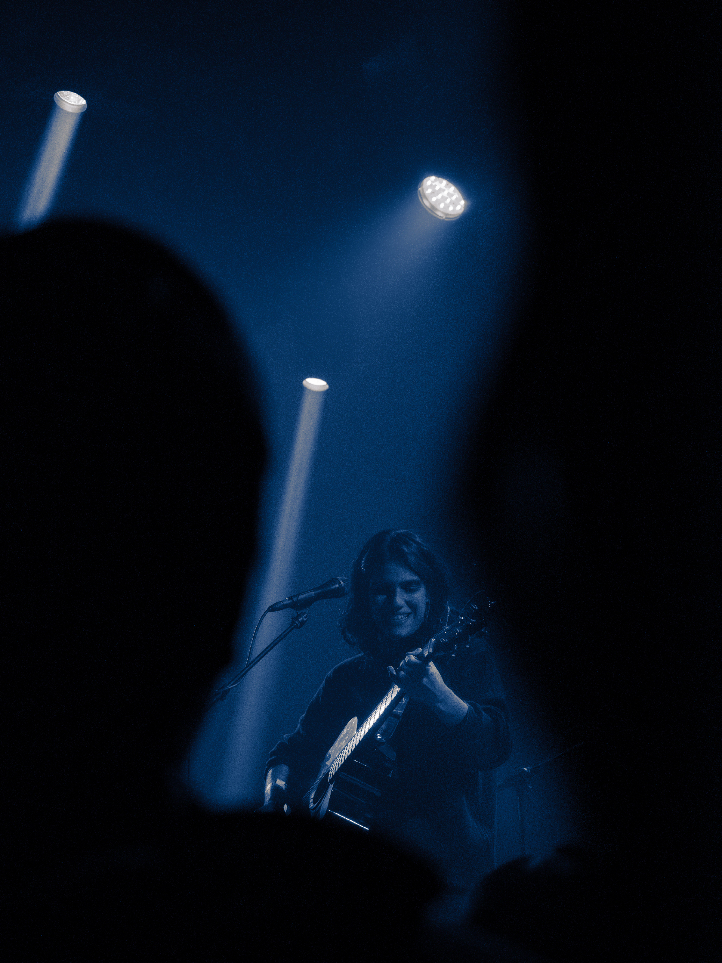 Nara smiles, framed by the silhouettes of people in the crowd.