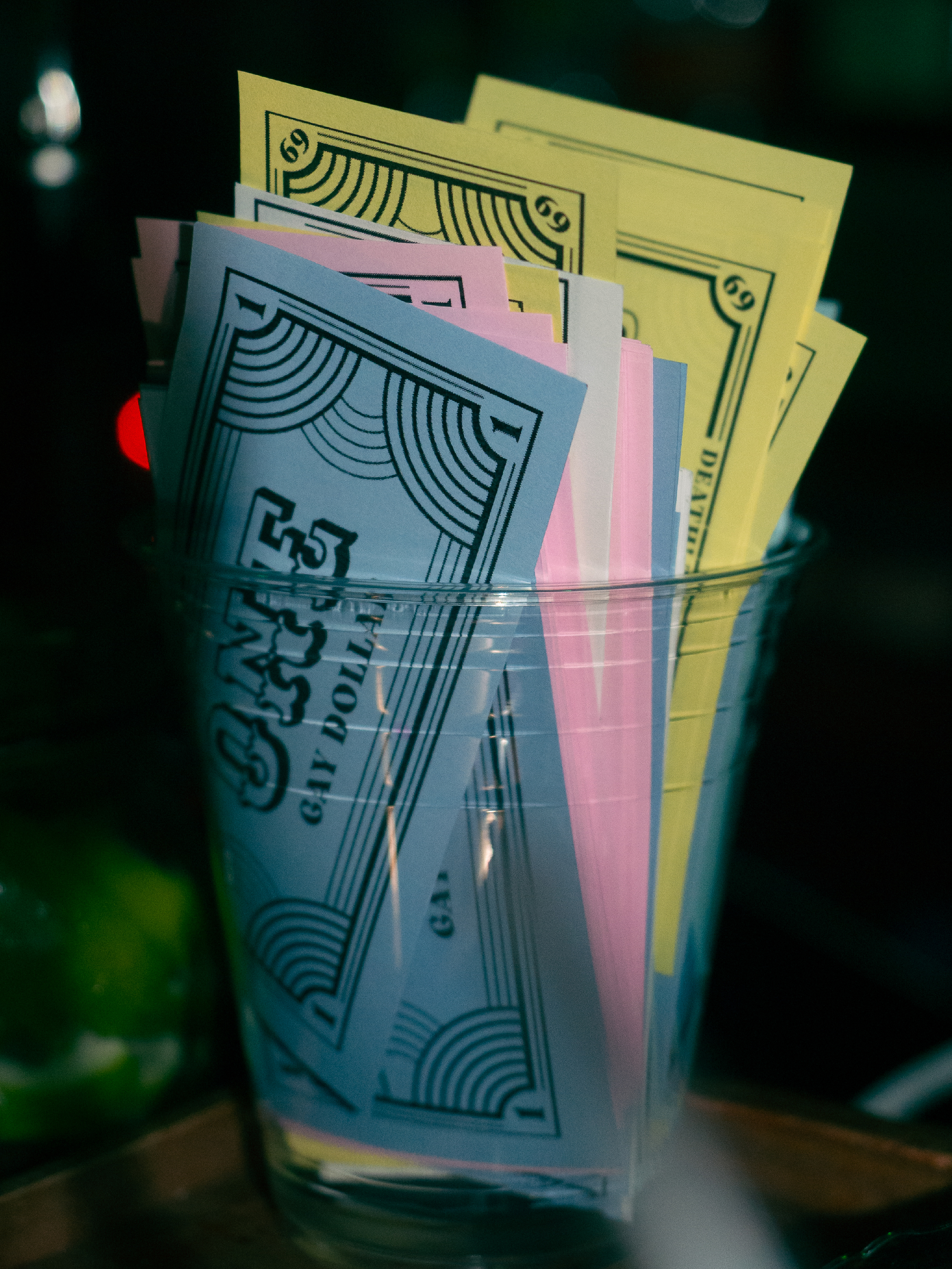 Prop money fills paper cup.