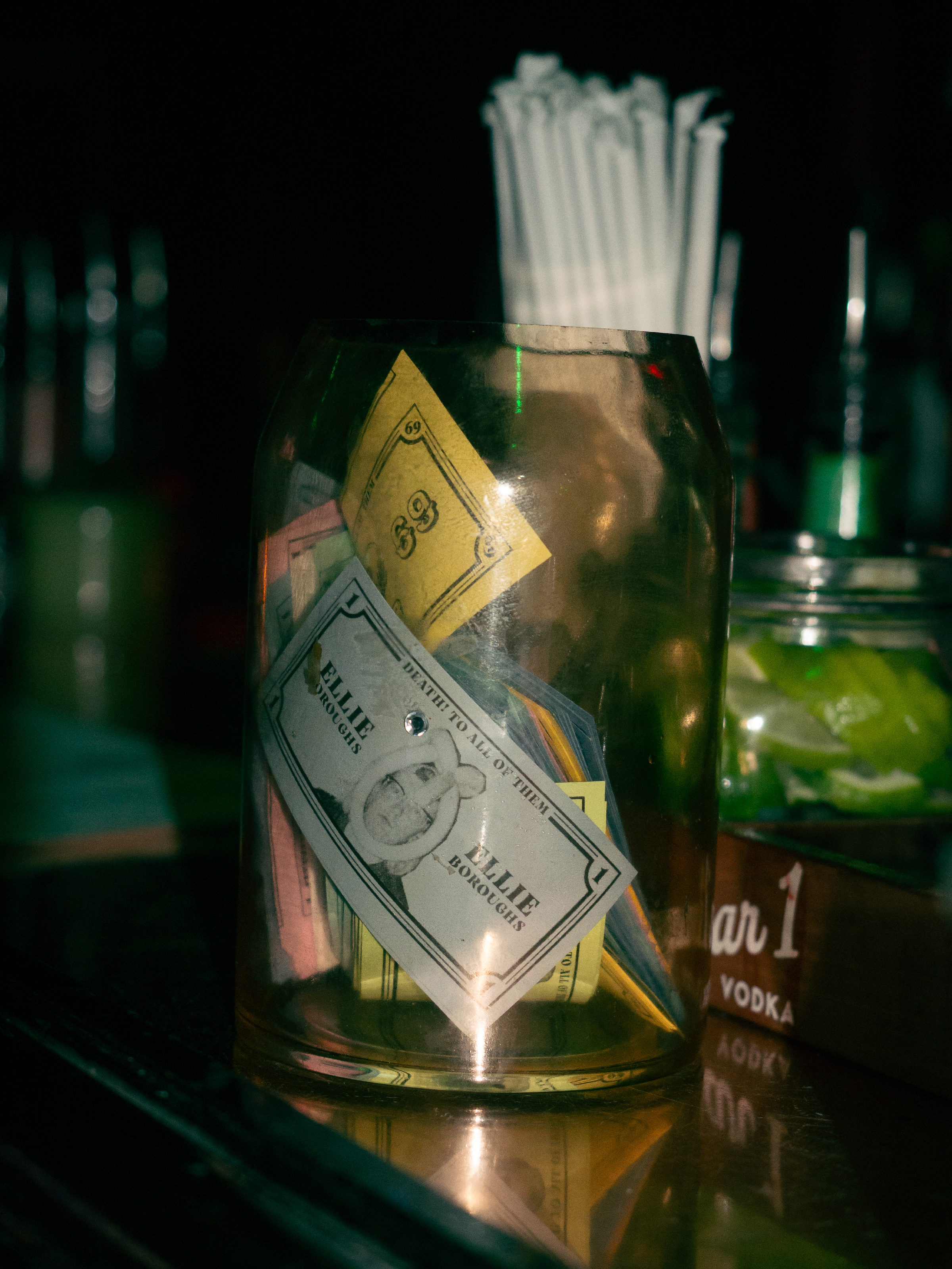 Prop money fills the tip jar on the bar.