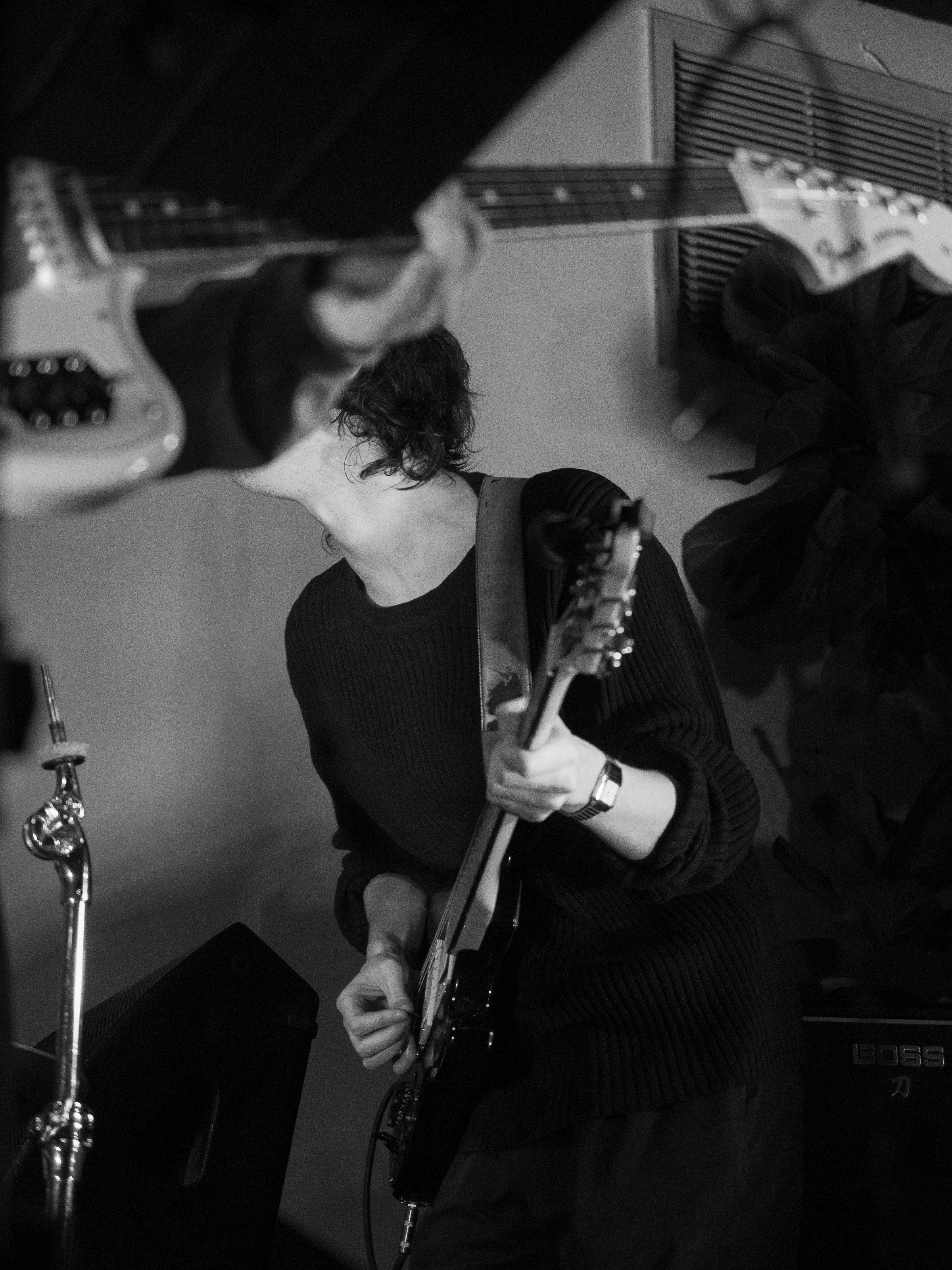 Ben plays guitar, face obscured by Nara's guitar's neck.