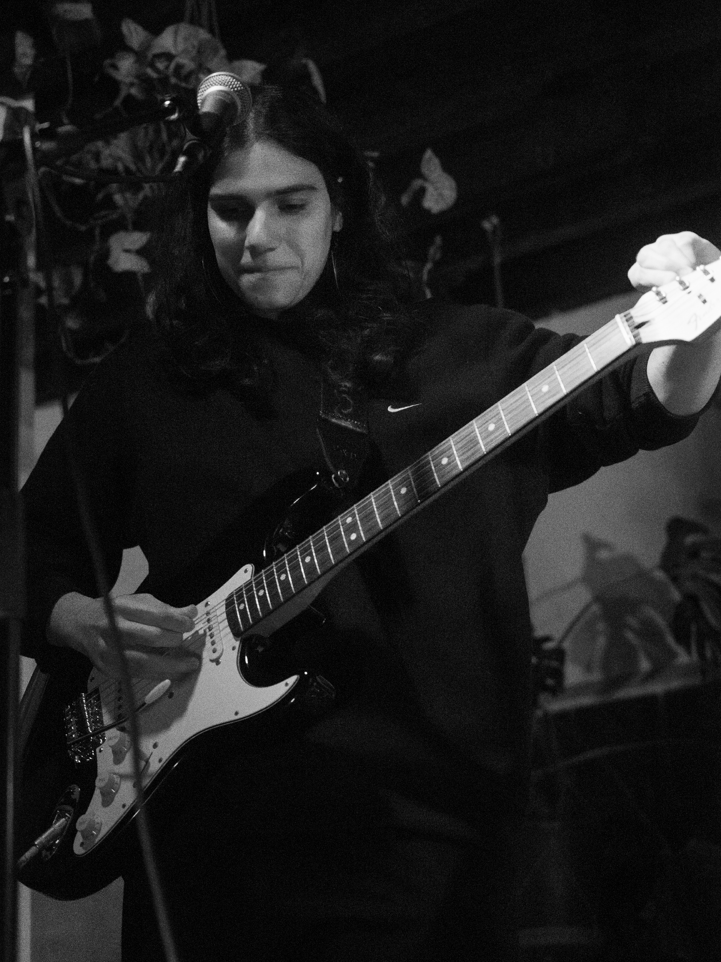 Nara smiles while tuning their guitar.