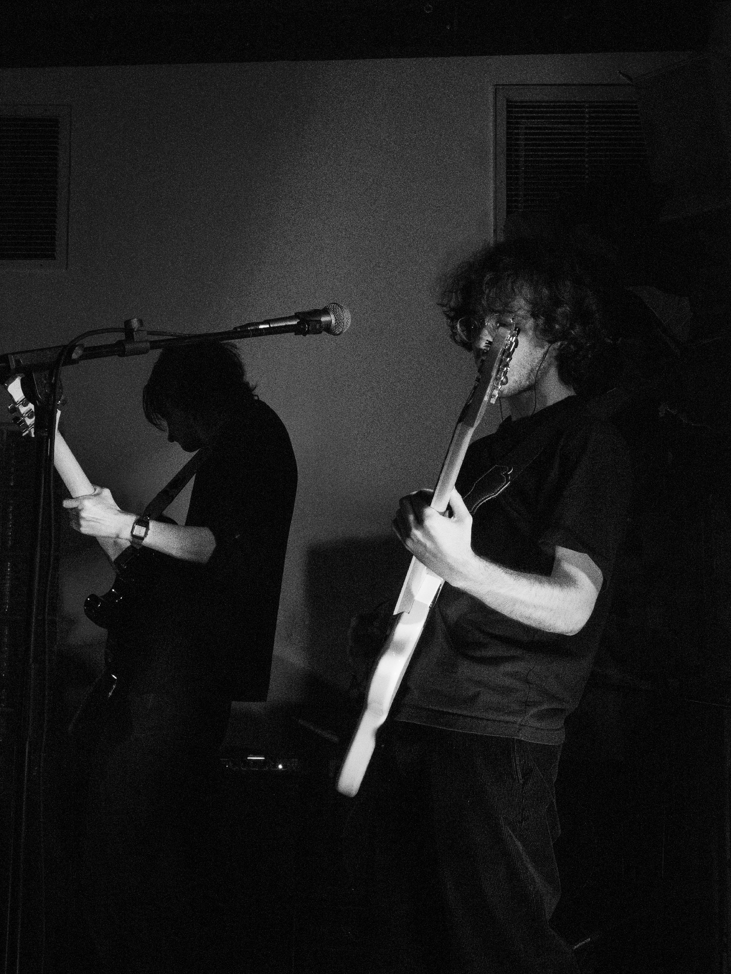 Trevor plays guitar. Ben is silhouetted in the background.