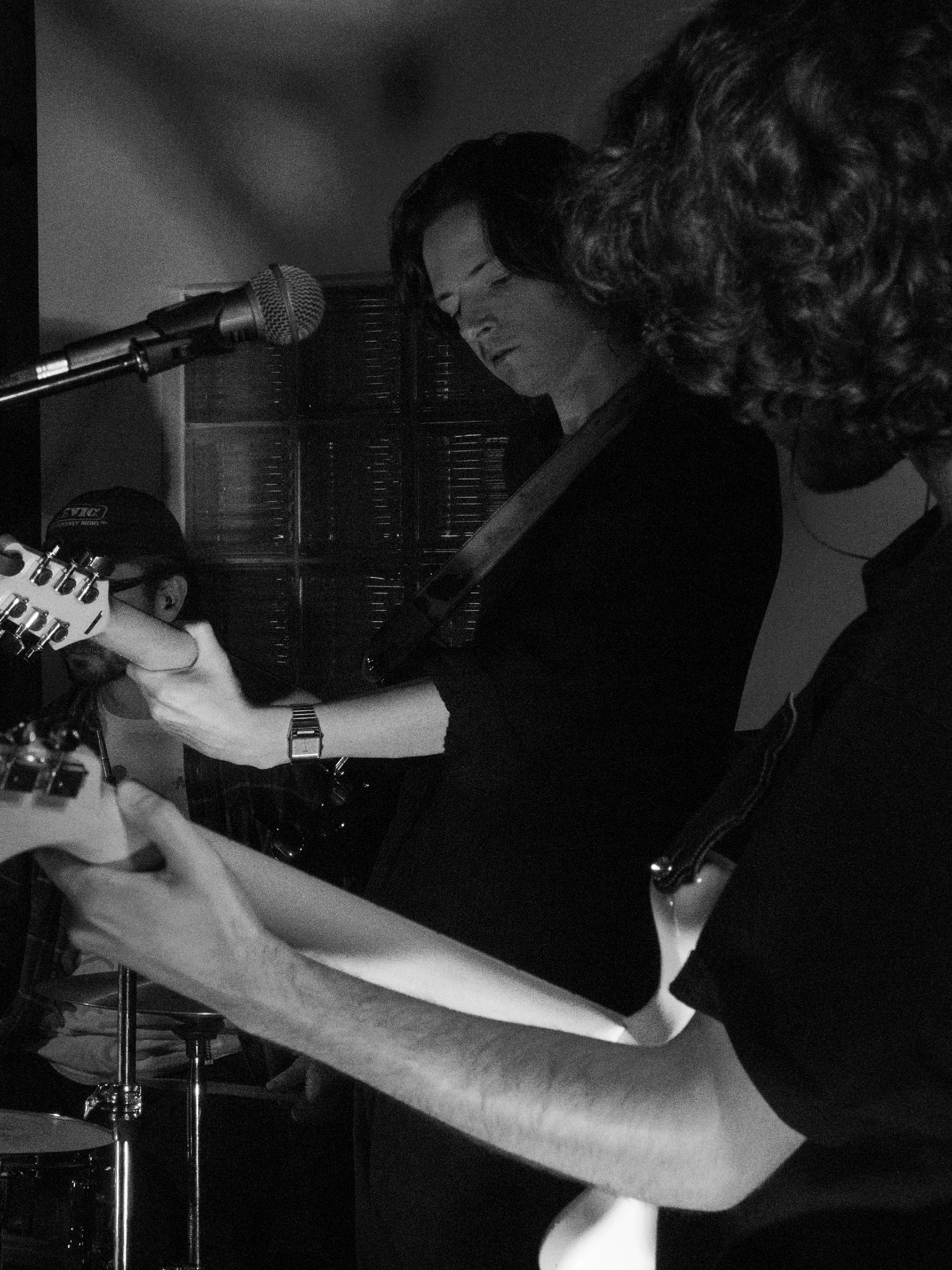 Ben plays guitar in the background, framed by Trevor playing guitar in the foreground.