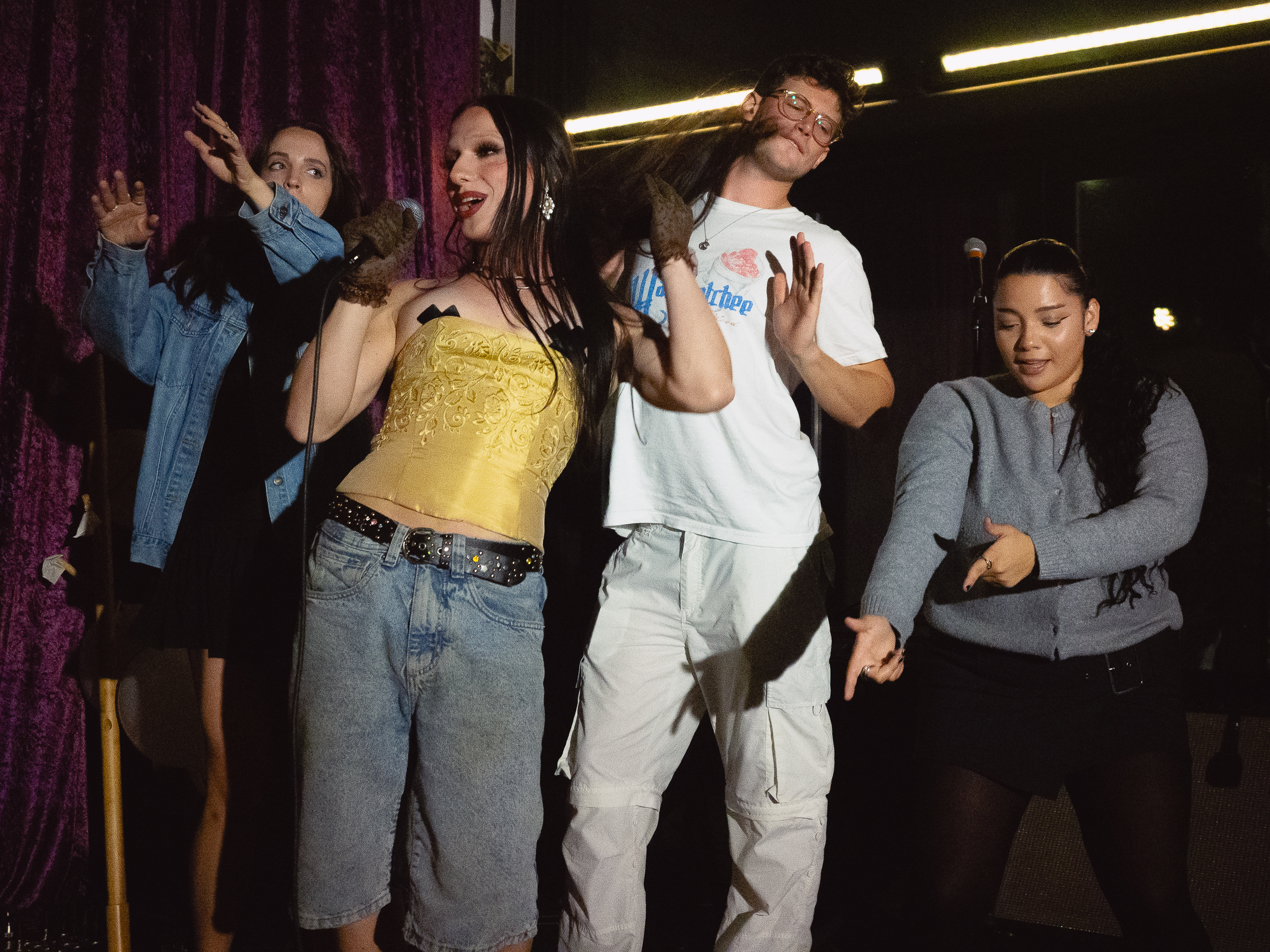 Host, Tina Hand, on stage with Amelia Ritthaler, Ben Jenkins, and Michelladonna.